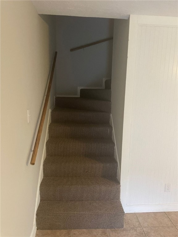 Stairs featuring baseboards and tile patterned flooring