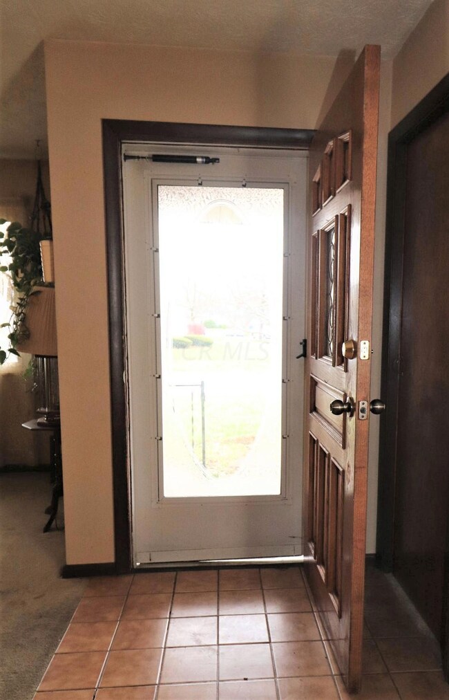 Tiled foyer and coat closet