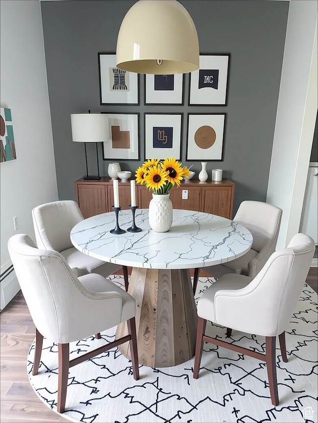 Dining room featuring wood finished floors, baseboards, and baseboard heating