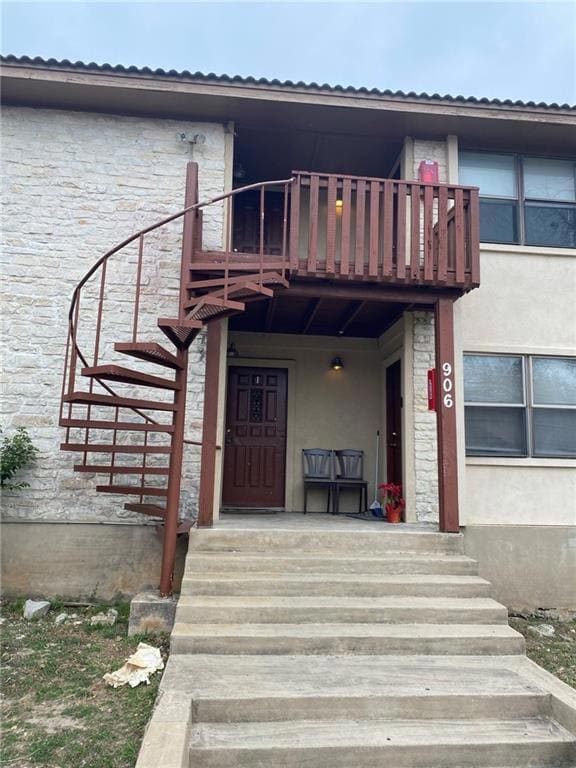Property entrance with stone siding, stucco sidin