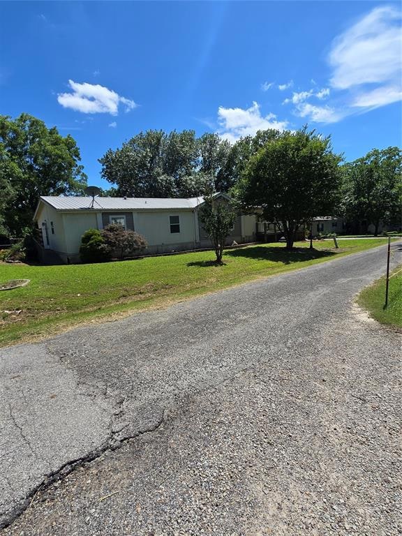 View of front of property featuring a front lawn and gravel driveway