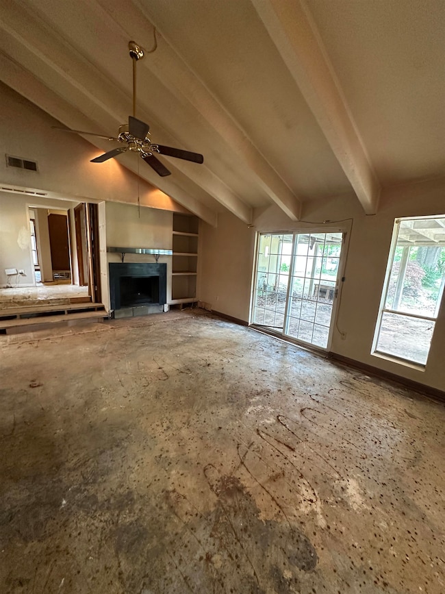Unfurnished living room featuring a ceiling fan, a fireplace, and baseboards