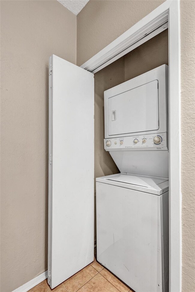 Laundry room with light tile patterned flooring an