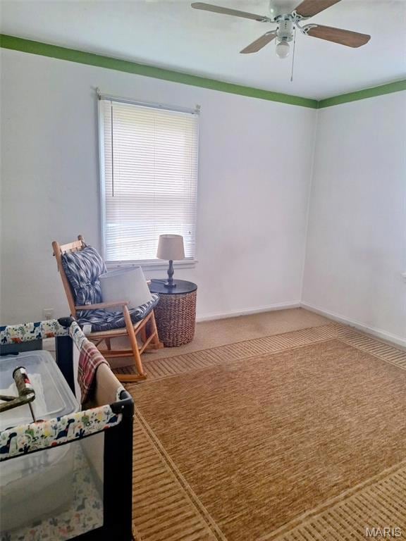 Carpeted home office with baseboards and ceiling fan