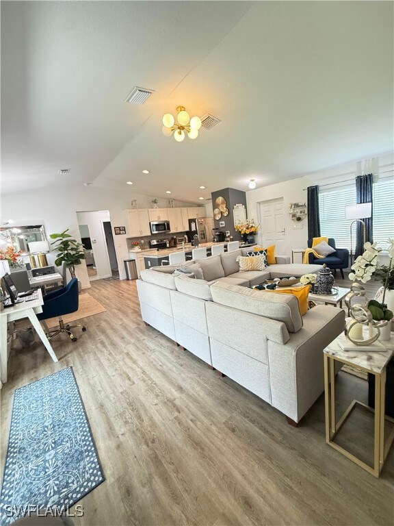 Living room with vaulted ceiling, light wood-style