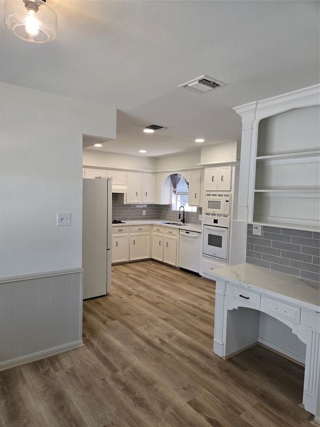 This kitchen features clean white cabinetry, moder