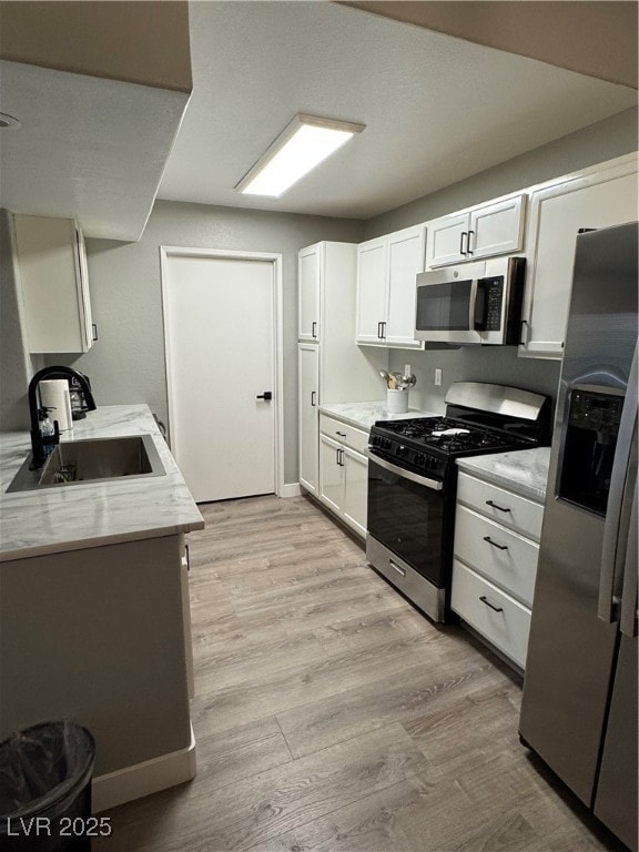 Kitchen featuring light wood-style floors, a sink,
