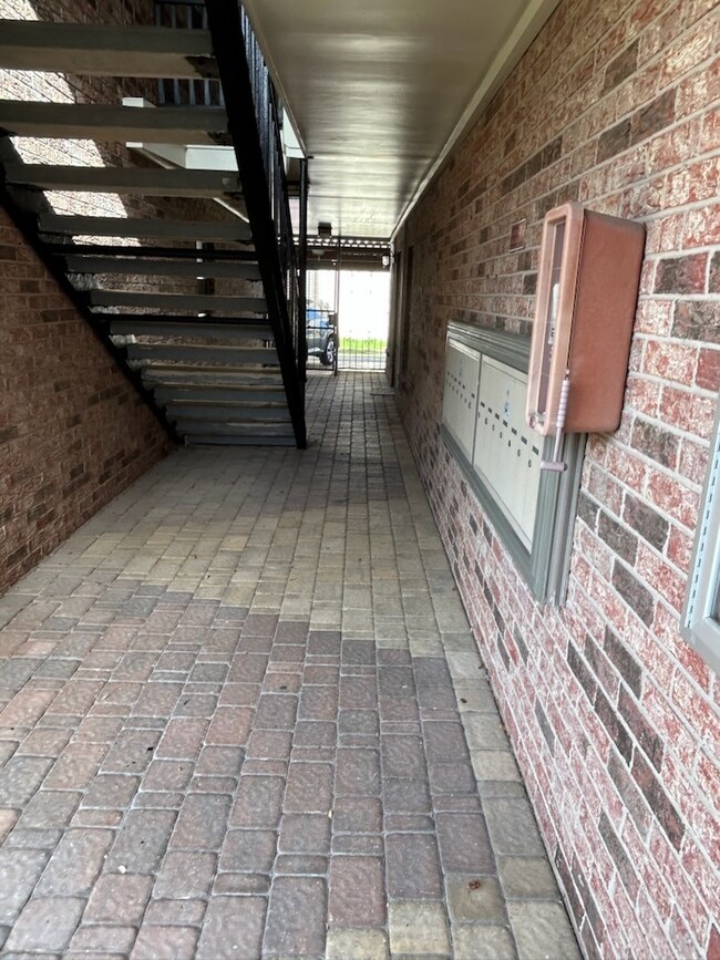 Covered walk-way to the carports and alley with the mailboxes on the right. The condo #109 front door to the immediate left.