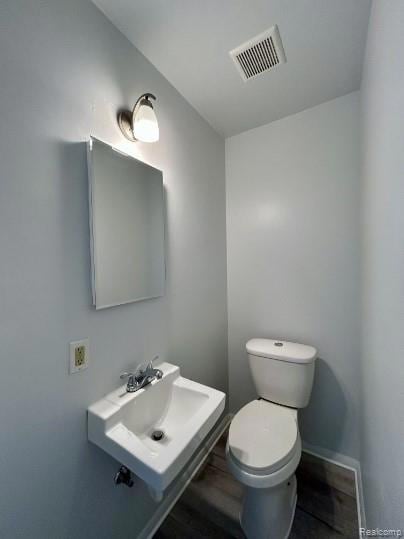Bathroom featuring toilet and wood finished floors