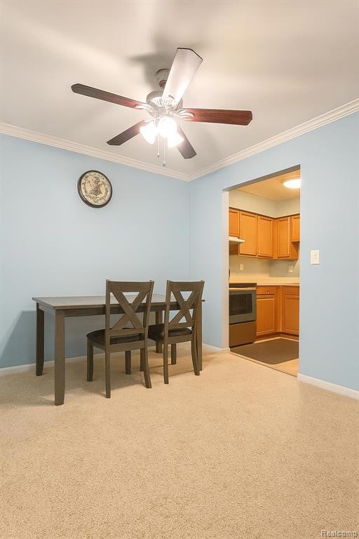 Dining area featuring crown molding, light carpet, and a ceiling fan