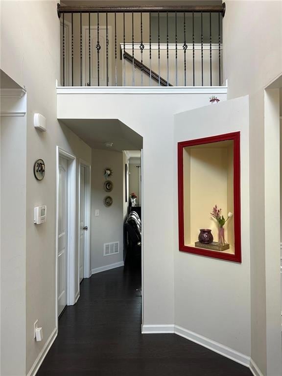 Hallway featuring a towering ceiling, visible vent