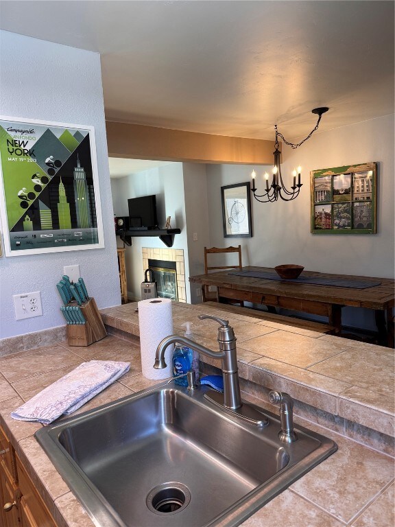 Kitchen with a tile fireplace, a notable chandelie
