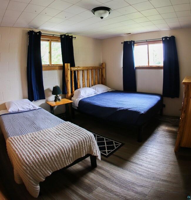 Bedroom with multiple windows and wood finished floors
