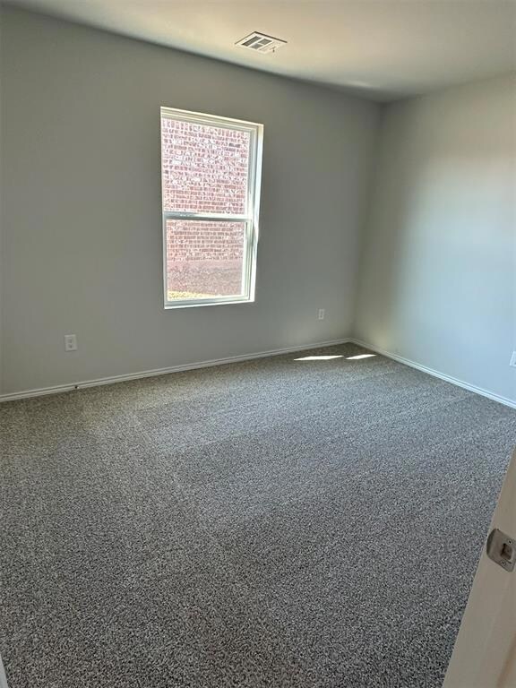 Empty room featuring carpet floors, baseboards, an