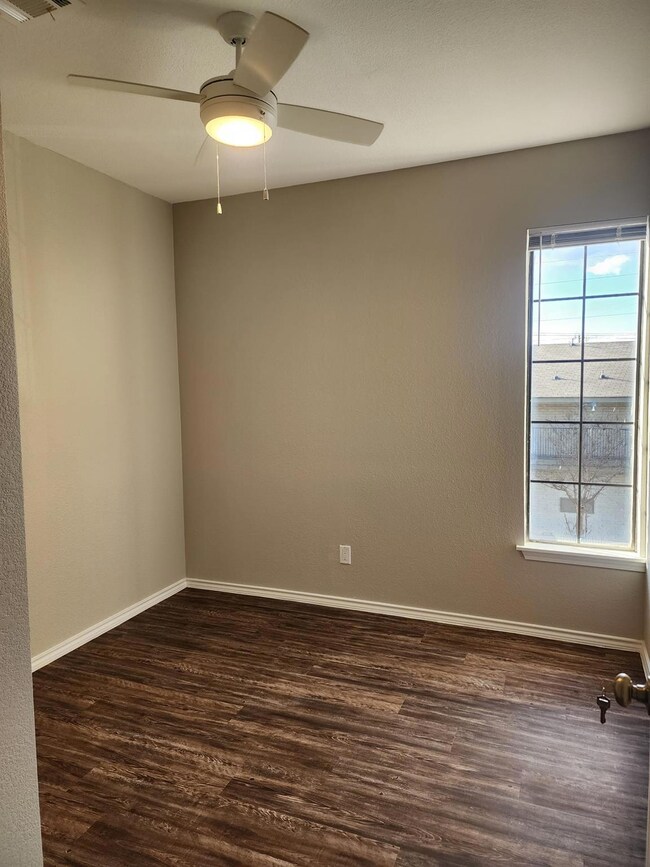 Spare room featuring dark wood finished floors, b