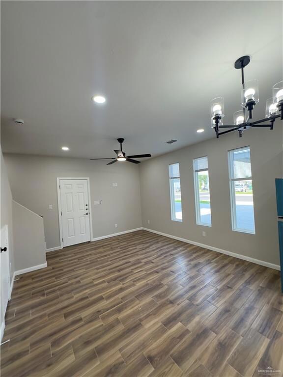 Unfurnished room with a chandelier, dark wood-style flooring, baseboards, ceiling fan, and recessed lighting