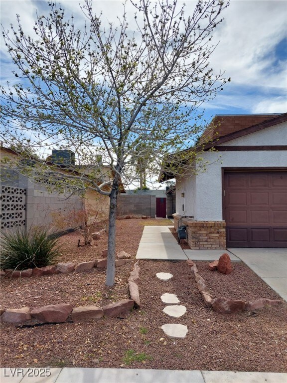 View of yard with concrete driveway, fence, and an