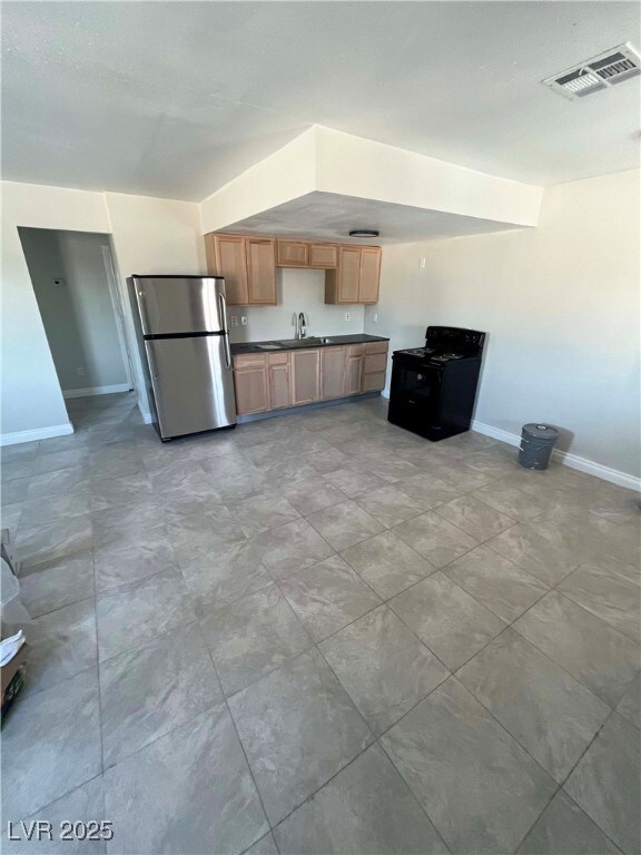Kitchen with freestanding refrigerator, a sink, da