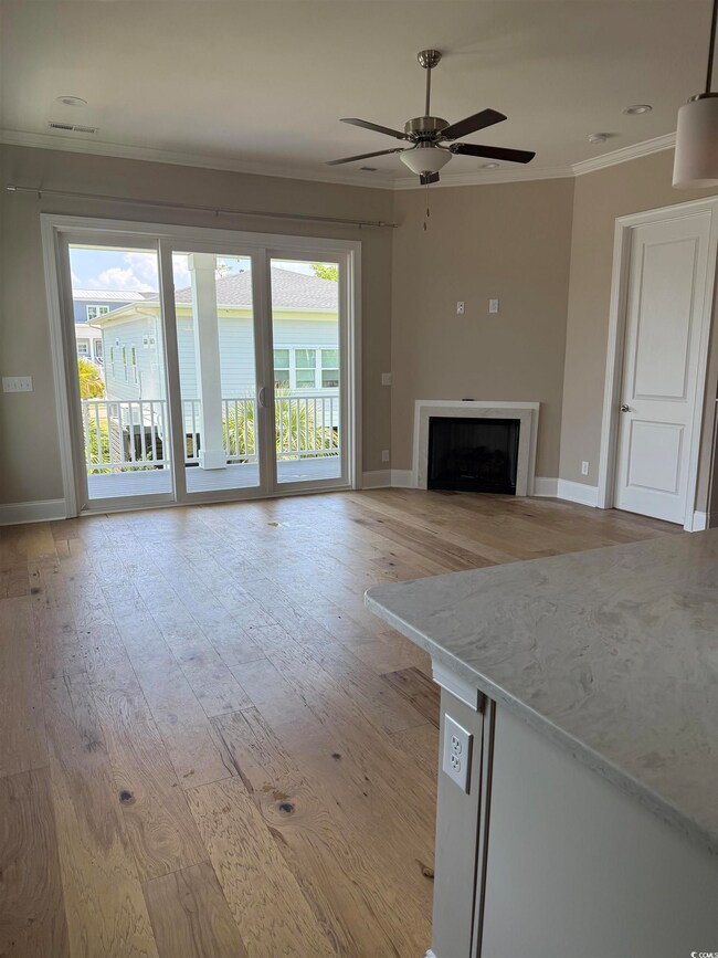 Unfurnished living room with ornamental molding, light wood finished floors, ceiling fan, and a fireplace