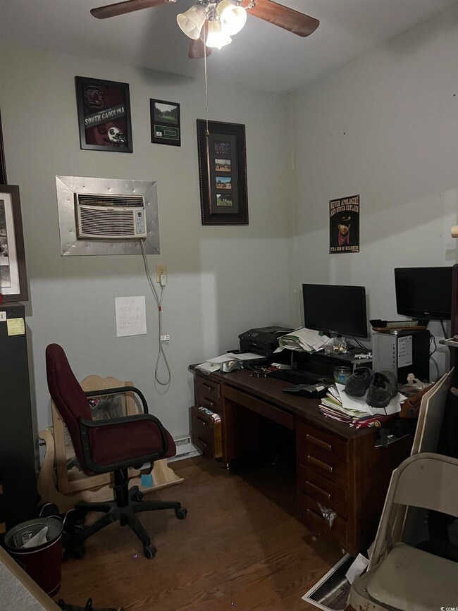 Home office featuring wood-type flooring, an AC wa