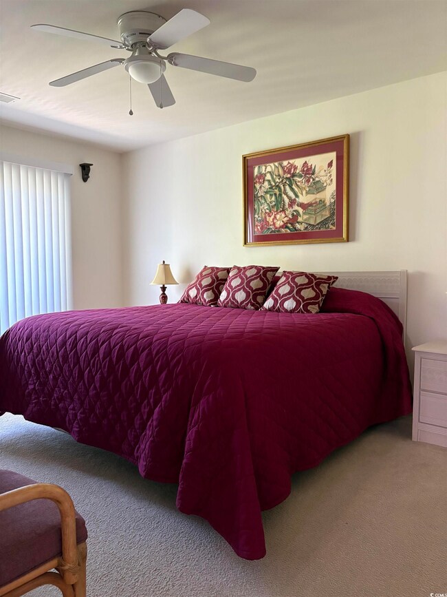 Bedroom with visible vents, a ceiling fan, and car