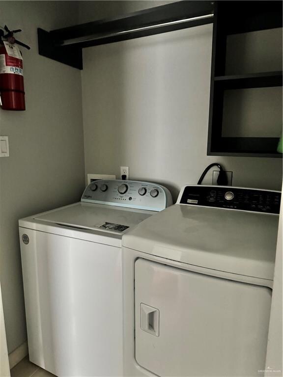 Laundry area featuring electric dryer hookup, washer hookup, and washing machine and clothes dryer