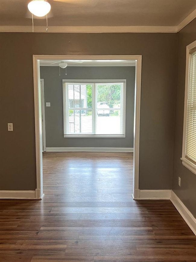 Unfurnished room with ornamental molding and dark 