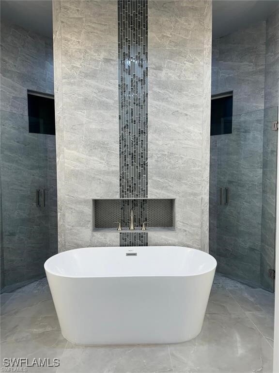 Bathroom with tile walls and shower with separate bathtub