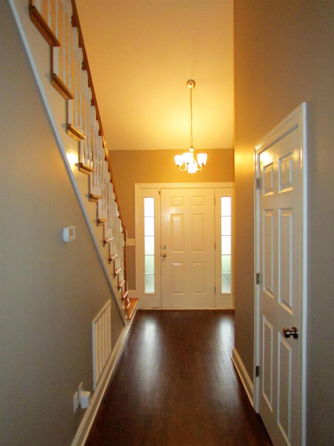 Foyer with nice stairway and wood work, and that is the half bath to the right