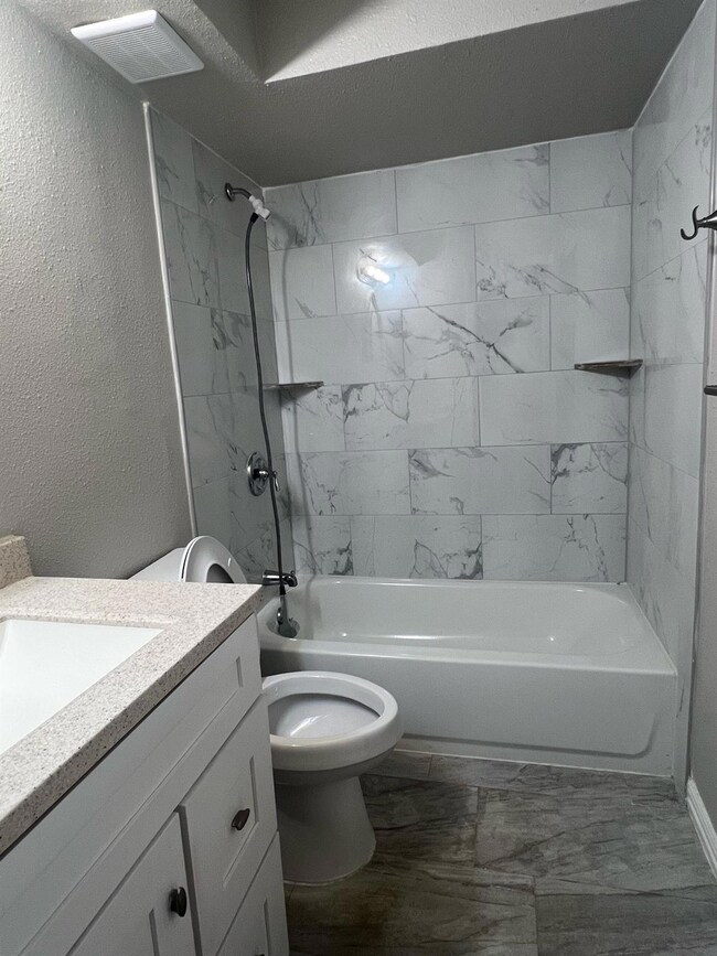 Full bathroom with toilet, tiled shower / bath com