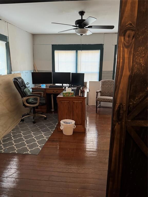 Home office with dark hardwood / wood-style floors