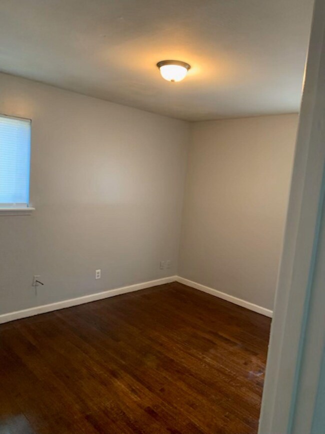 Empty room with dark hardwood / wood-style floors