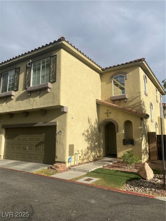 View of front facade with stucco siding, a garage,