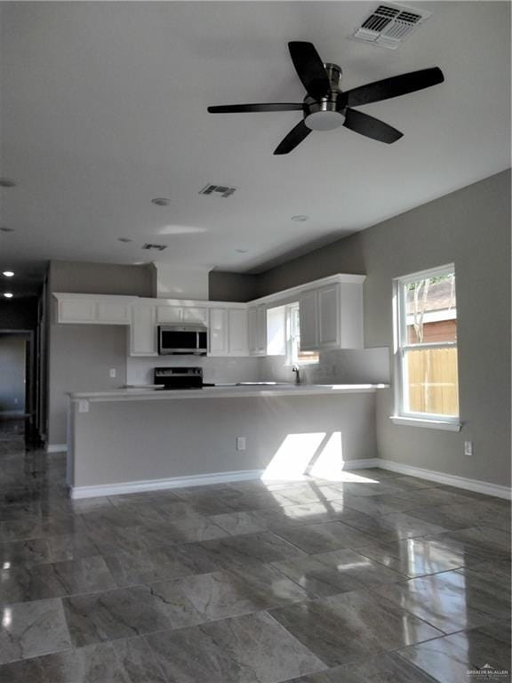 Kitchen with white cabinets, marble finish floor, and visible vents