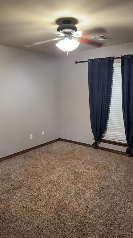 Spare room featuring carpet, a ceiling fan, and baseboards