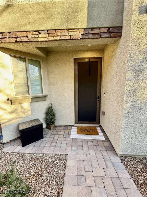Doorway to property featuring stucco siding
