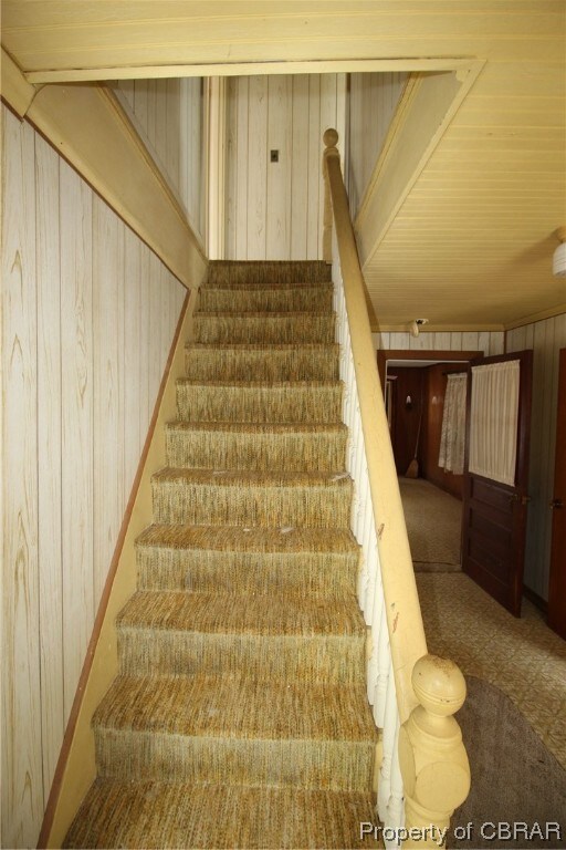 Stairway featuring light colored carpet