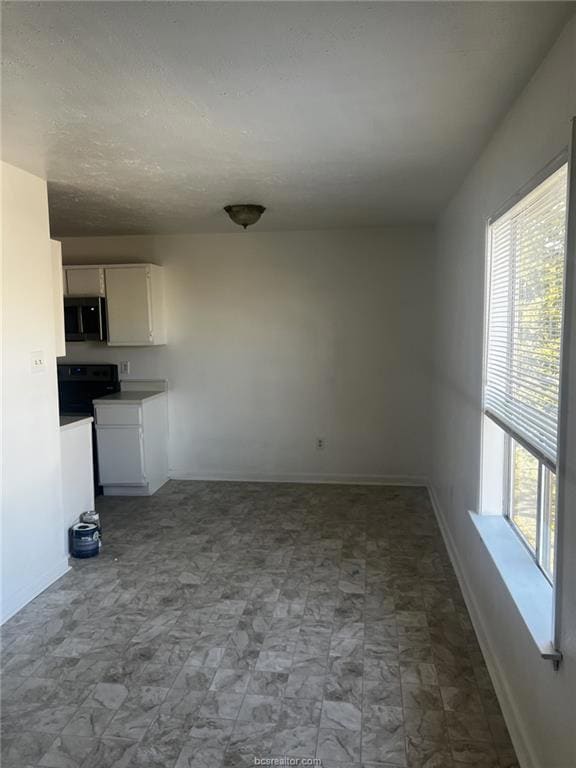 Unfurnished living room featuring a wealth of natural light