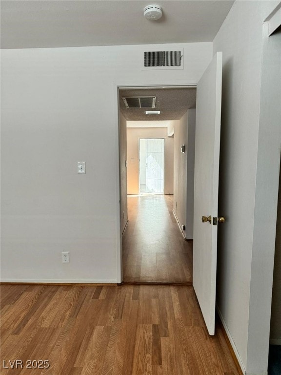 Hallway with wood finished floors and baseboards