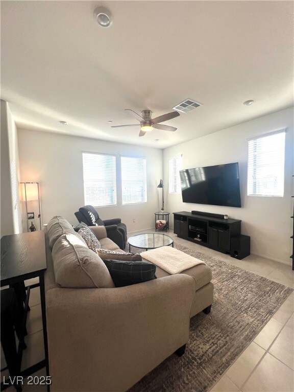 Tiled living area featuring ceiling fan