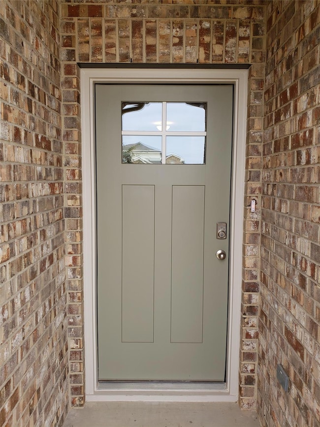 View of exterior entry with brick siding