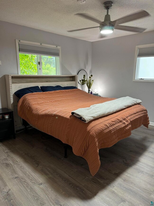 Bedroom with ceiling fan and wood-type flooring