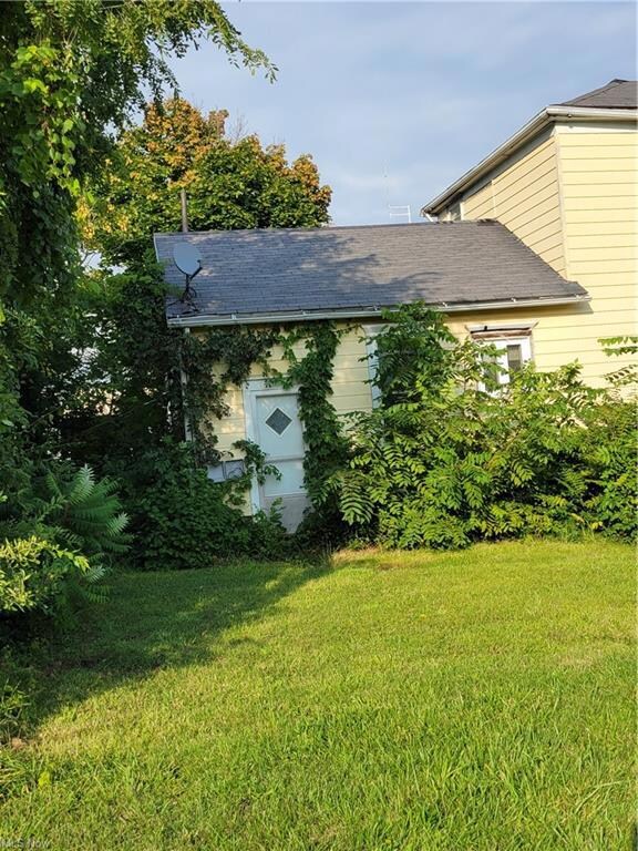 View of side of home with a lawn