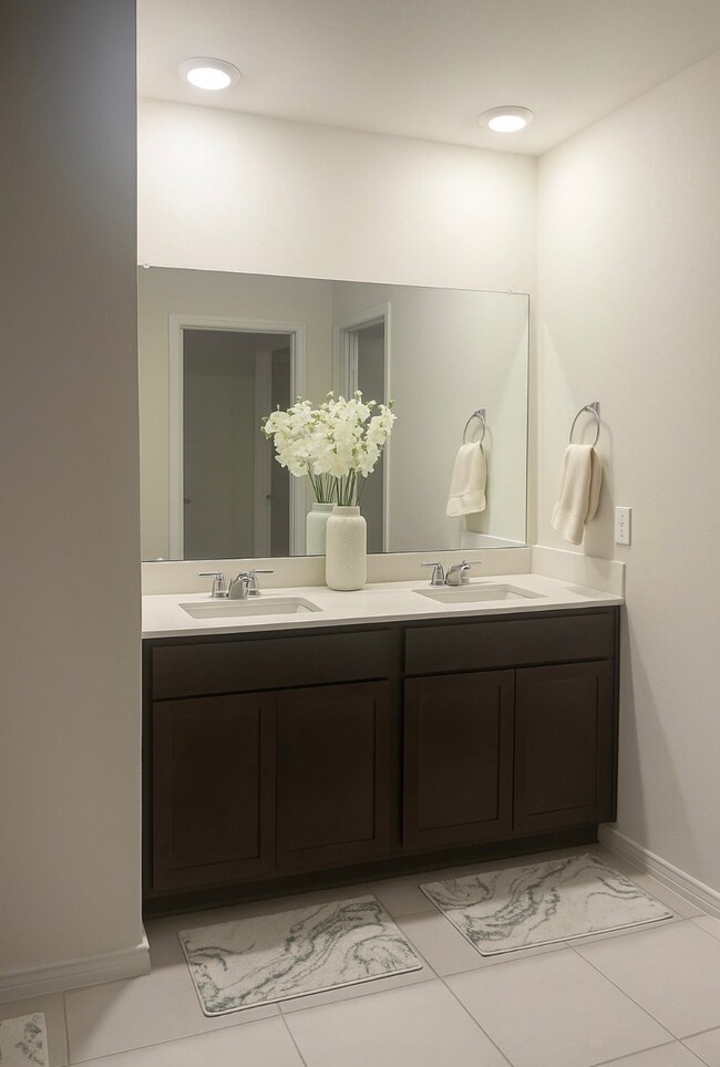 Bathroom featuring double vanity and light tile patterned floors