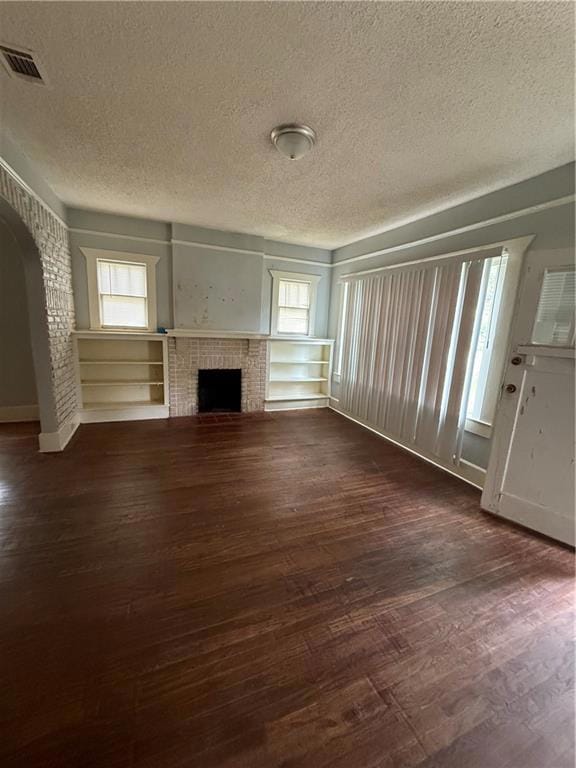 Unfurnished living room with arched walkways, a te