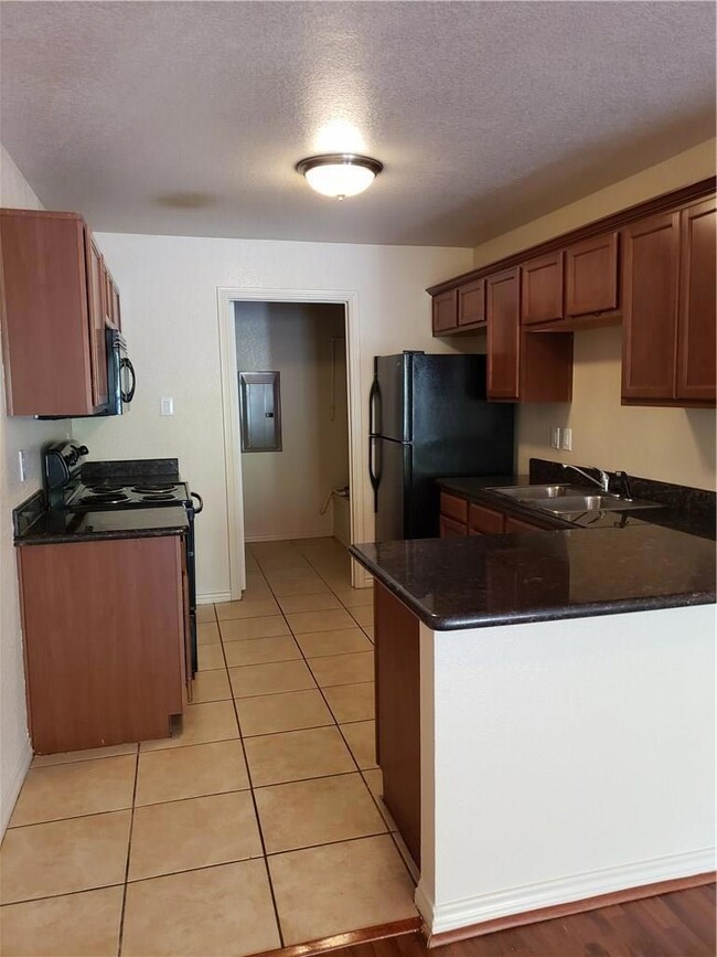 Kitchen featuring dark stone counters, kitchen pen