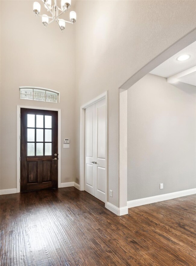 Foyer with a notable chandelier and dark hardwood / wood-style flooring