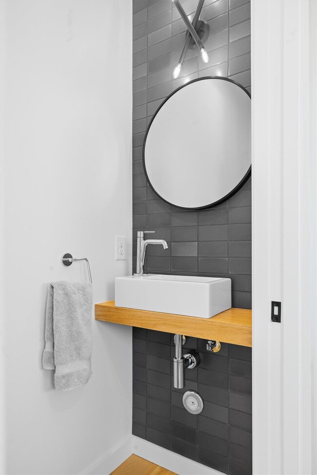 Bathroom with tile walls, a sink, and baseboards