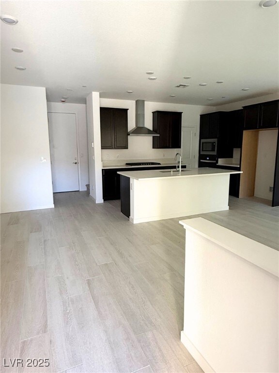 Kitchen with gas cooktop, light countertops, wall
