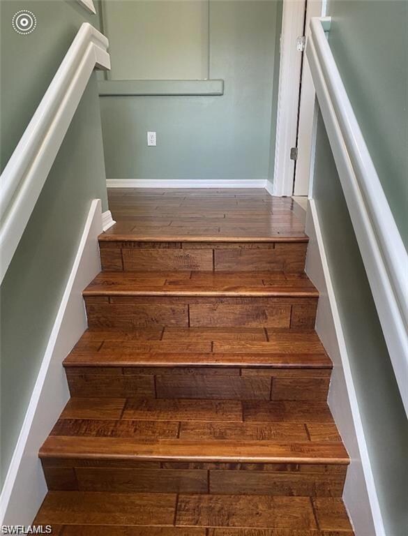Staircase featuring wood finished floors and baseb
